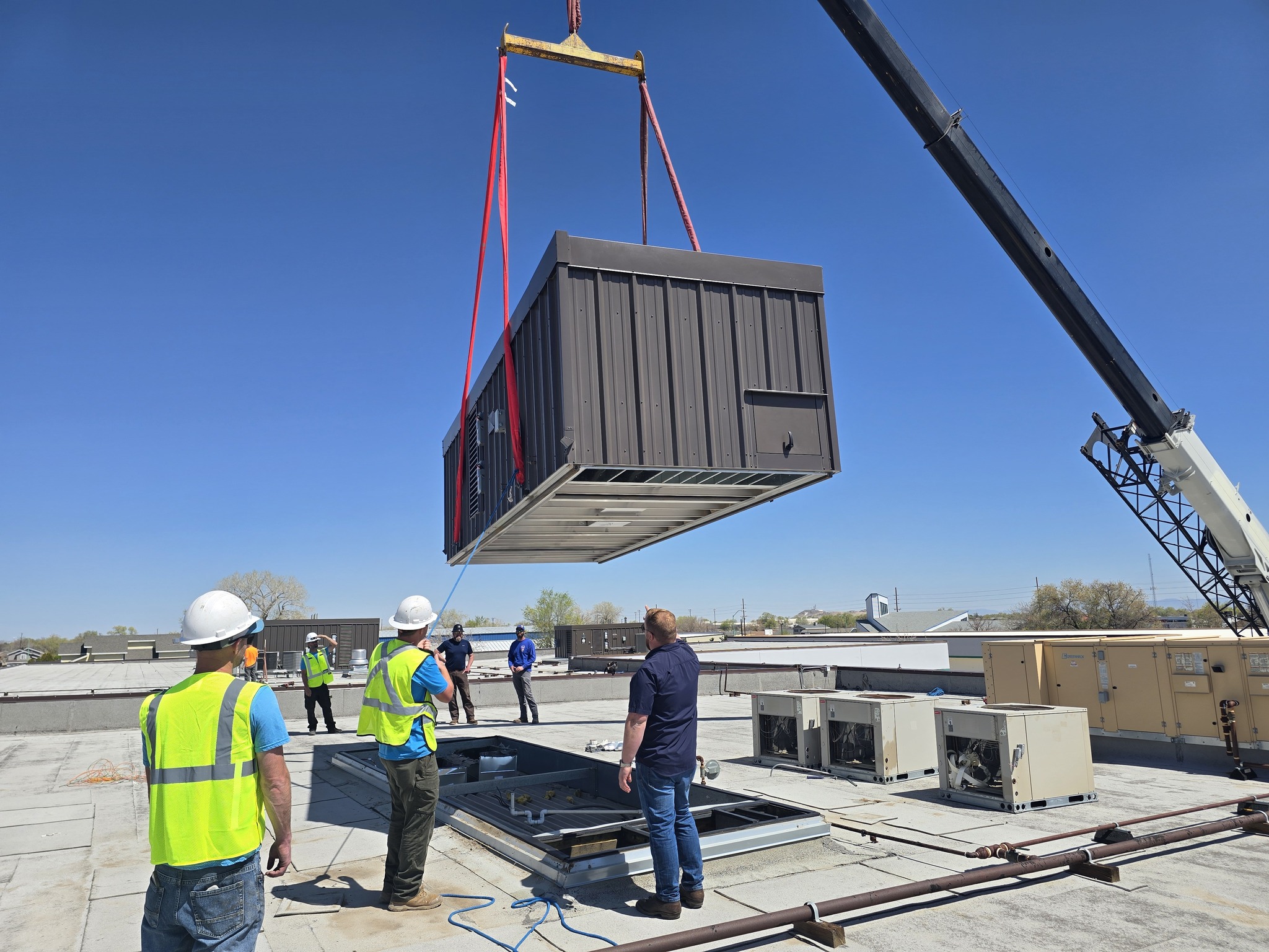 CME multizone HVAC unit being installed by crane on a commercial rooftop